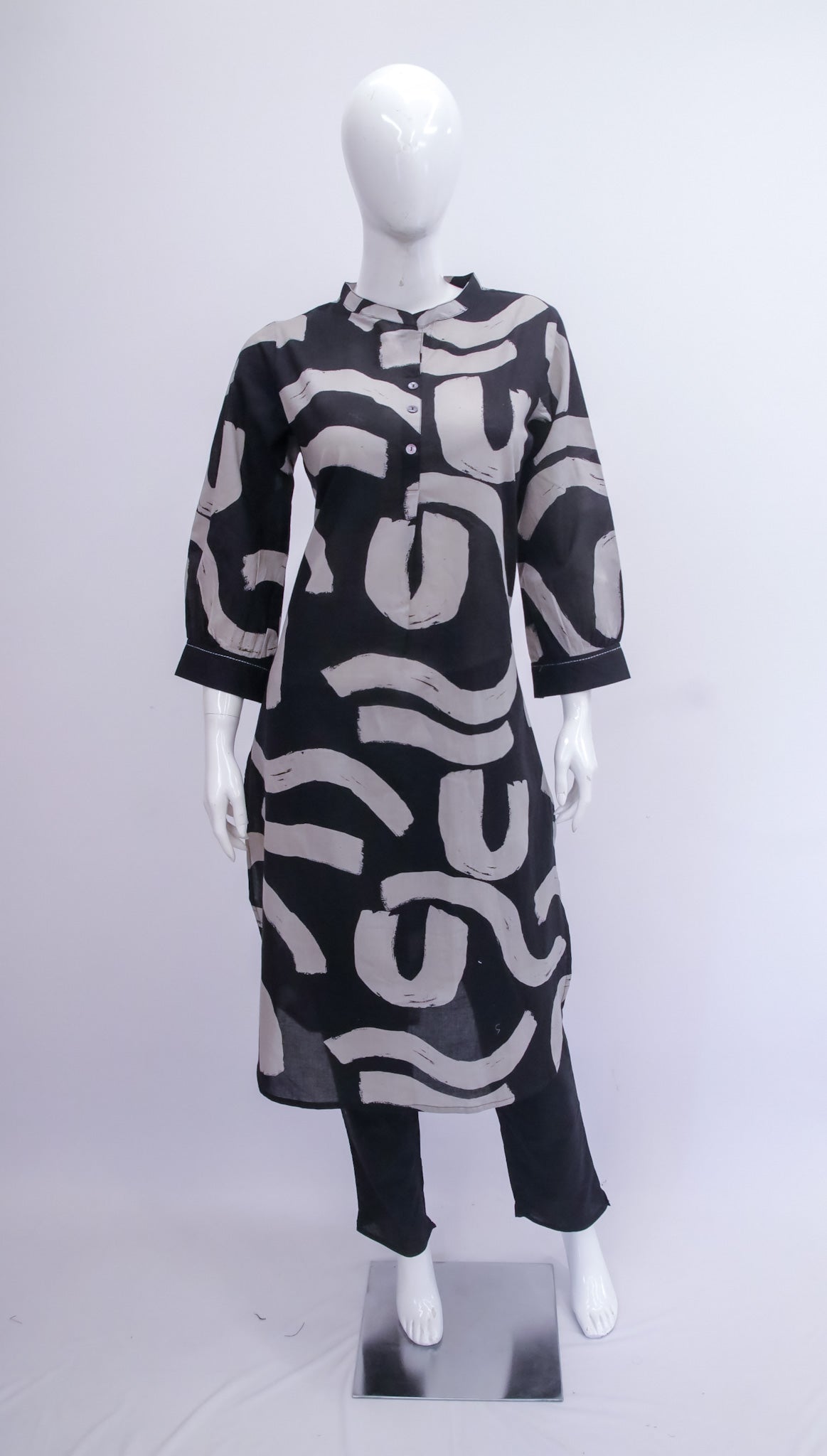 Mannequin wearing a black dress with white abstract patterns on a white background