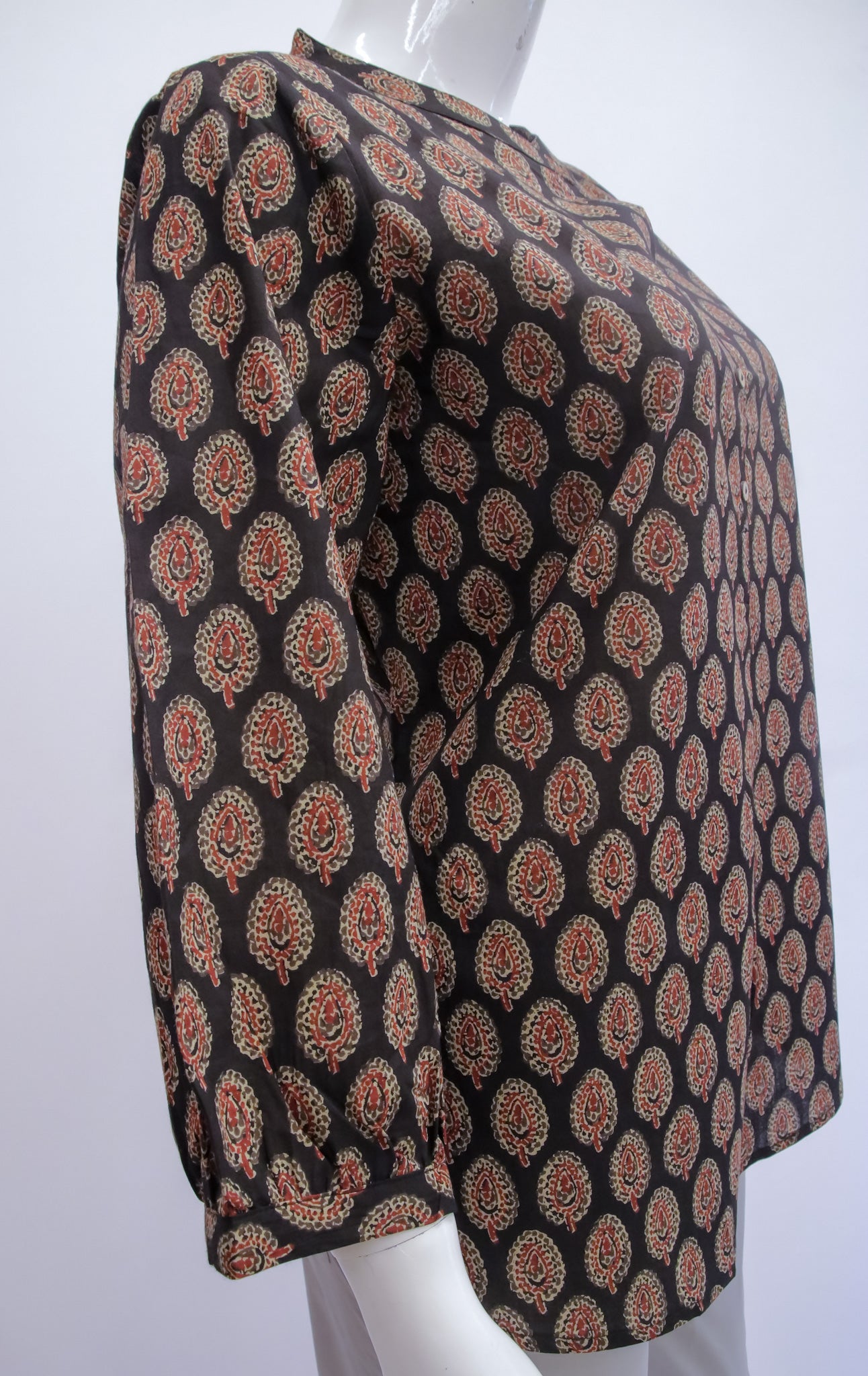 Mannequin wearing a black patterned top on a white background