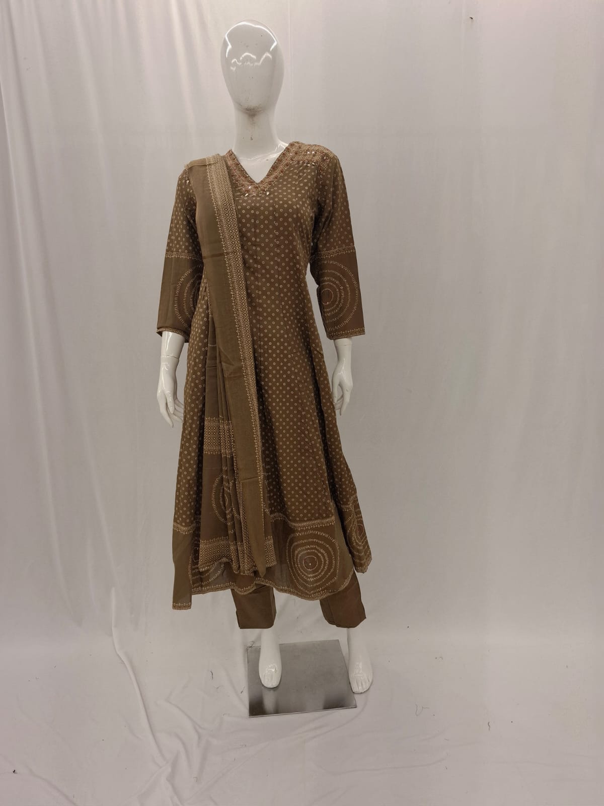 Brown dress with matching scarf on a mannequin against a white background