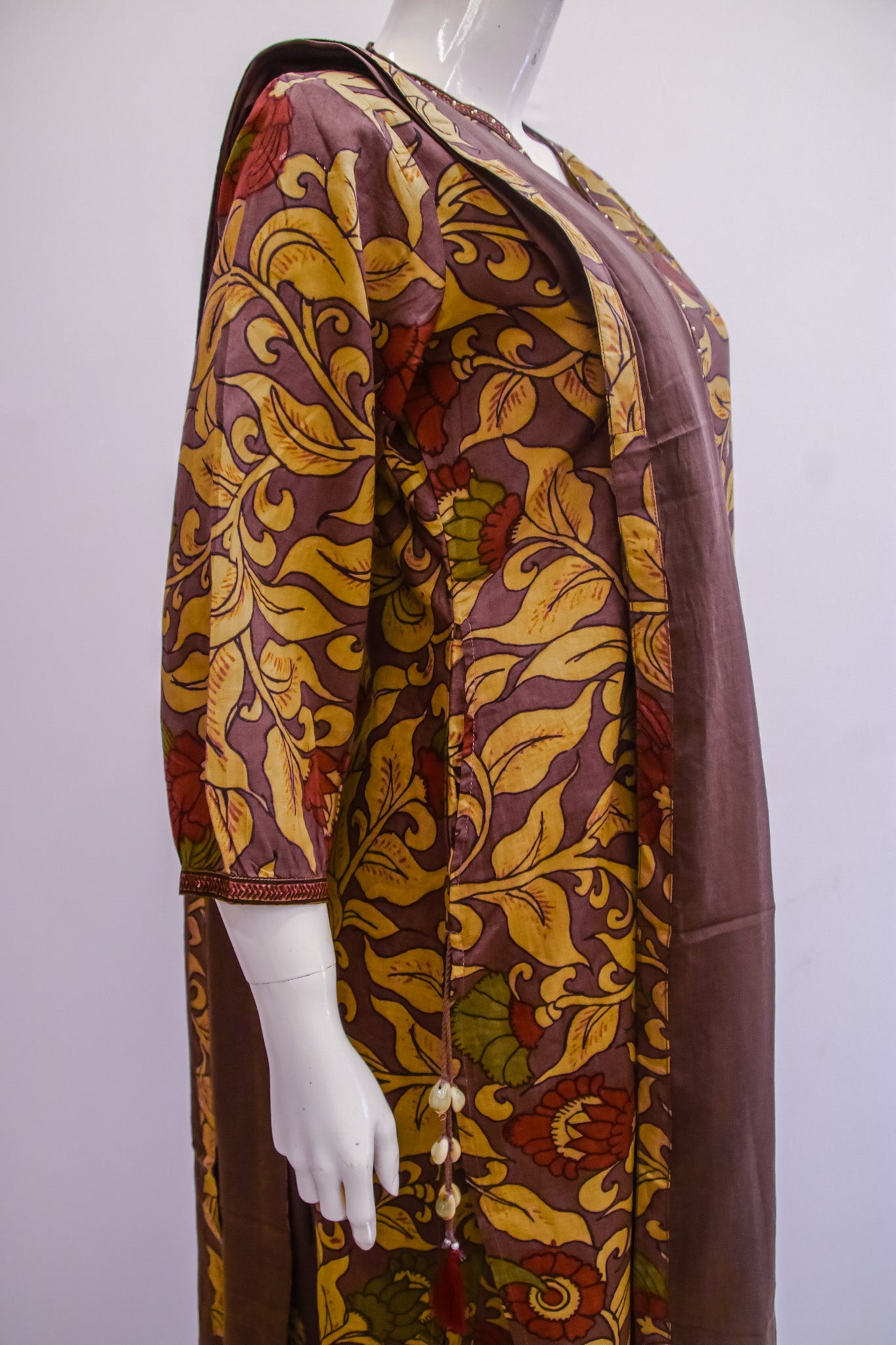 Mannequin wearing a patterned dress with a floral design on a white background
