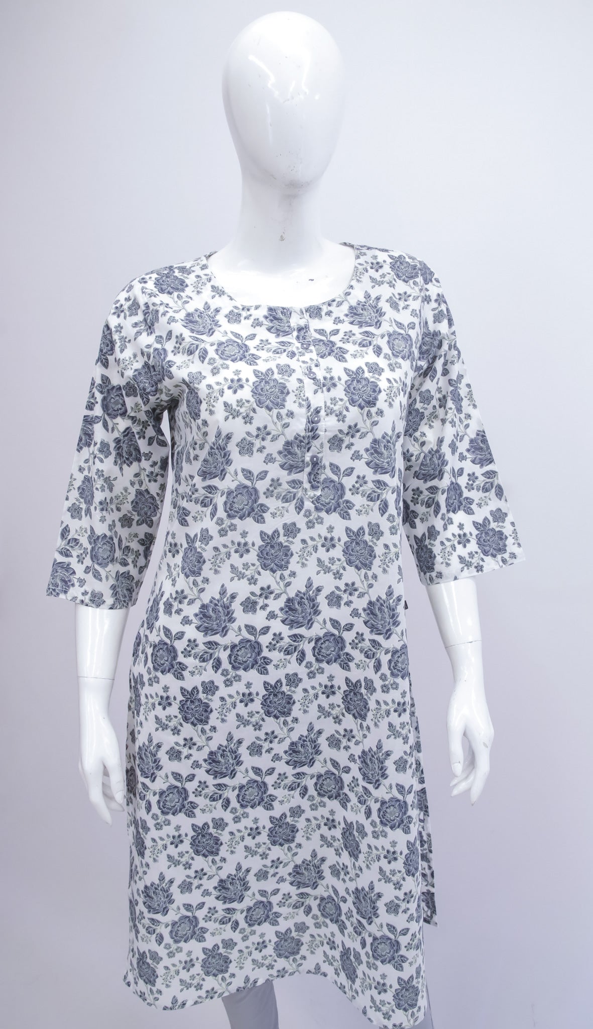 White dress with blue floral pattern on a mannequin against a gray background