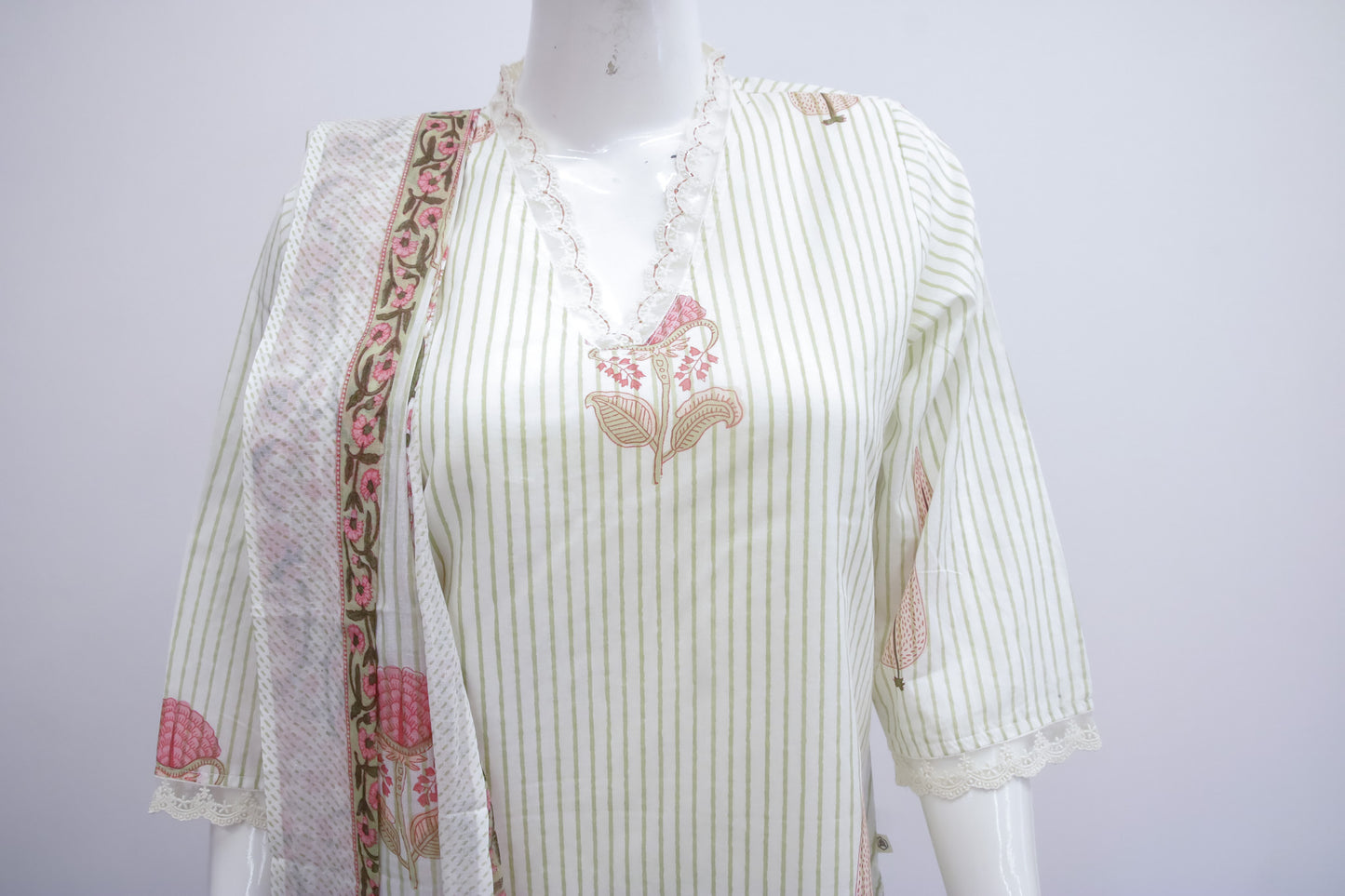 White striped shirt with floral embroidery on a mannequin against a white background
