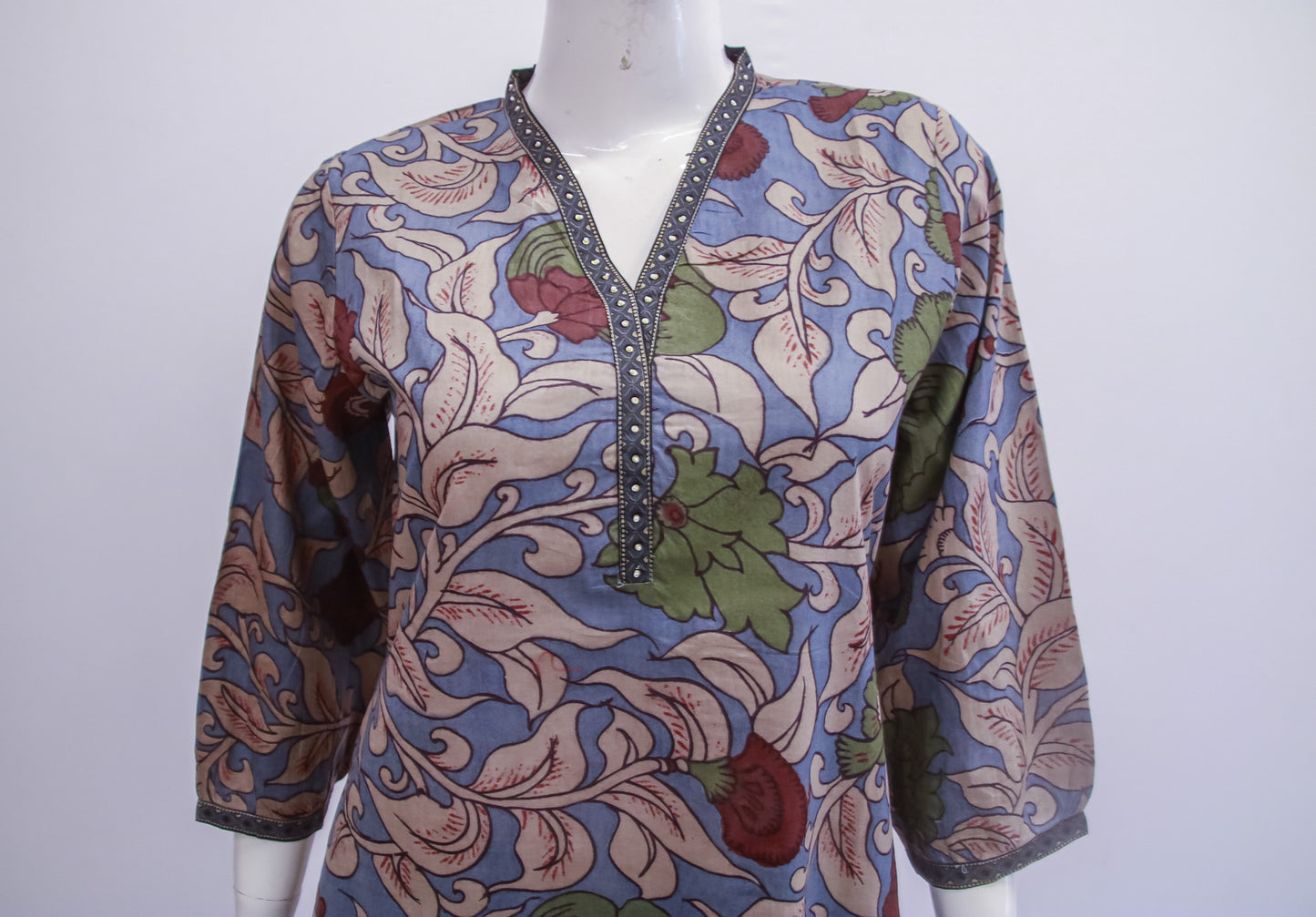 Colorful patterned top on a mannequin against a white background