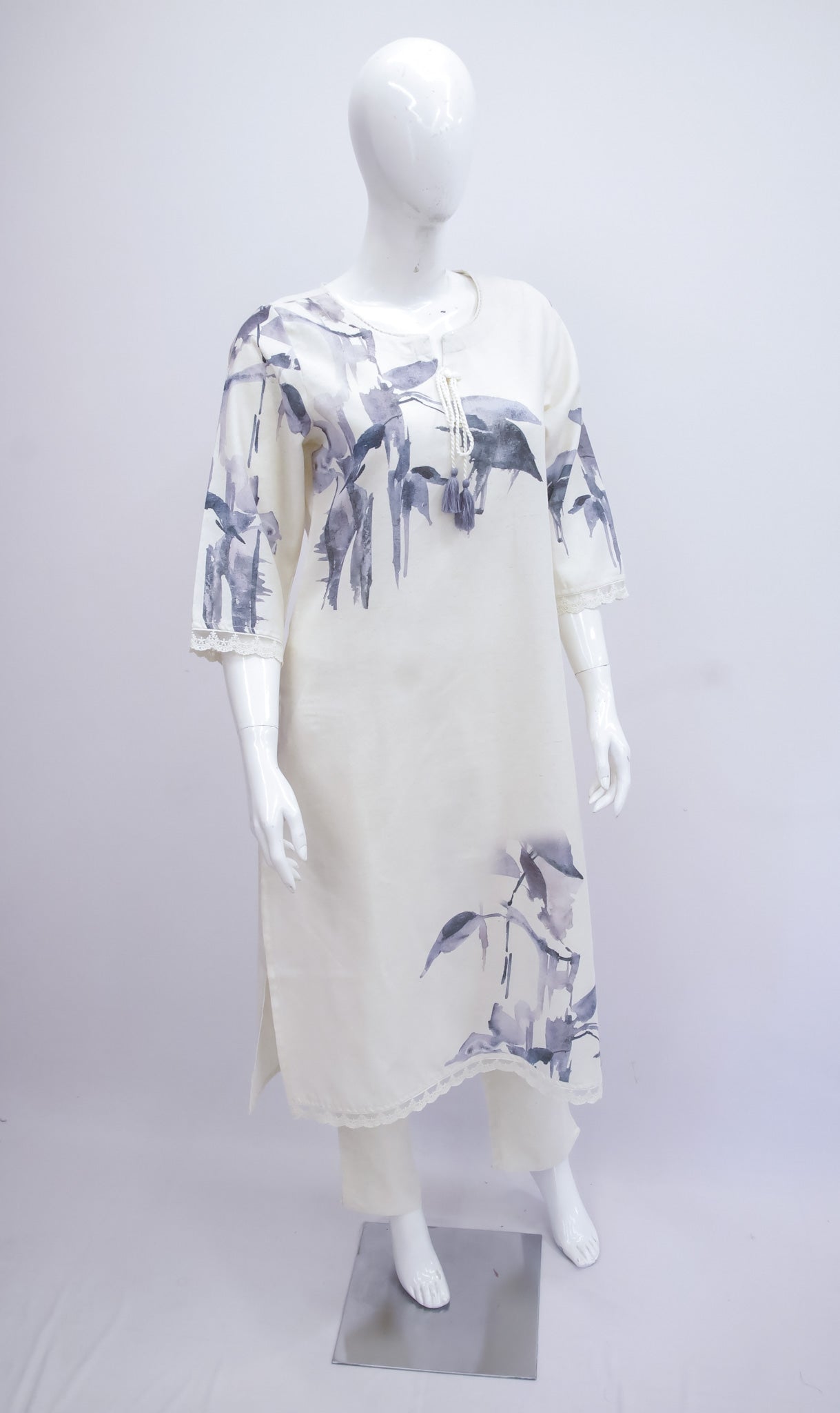 White dress with blue floral pattern on a mannequin against a white background