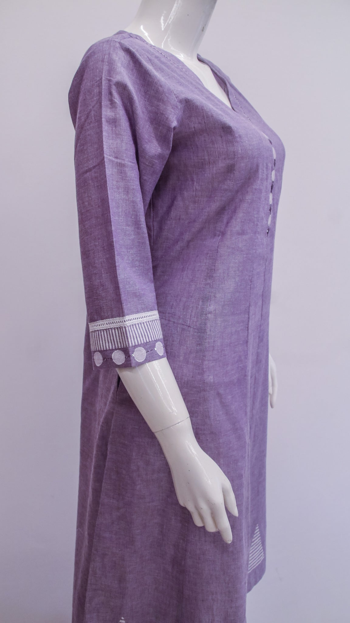 Purple dress with white trim on a mannequin against a plain background