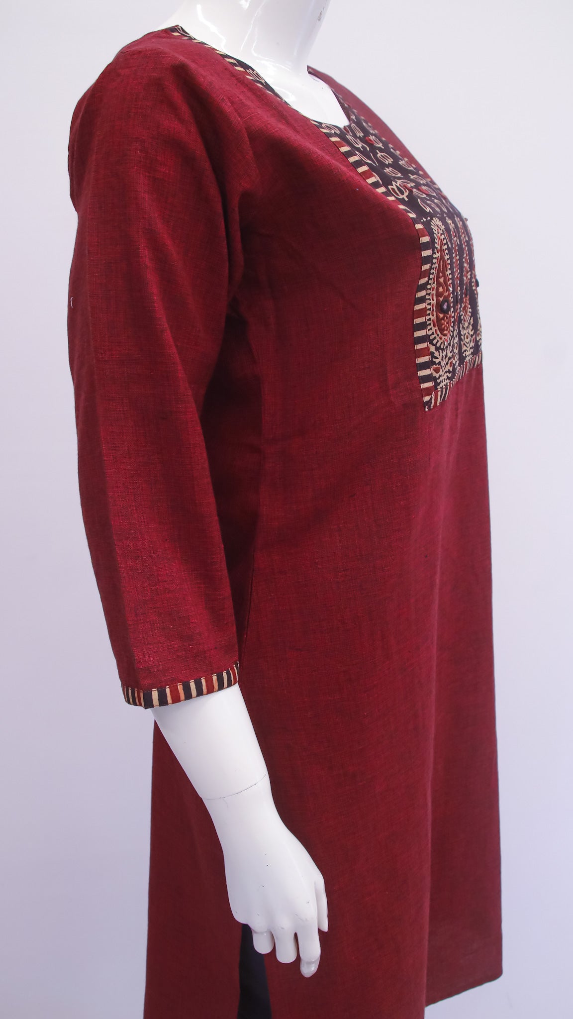 Maroon dress with intricate gold embroidery on a white background