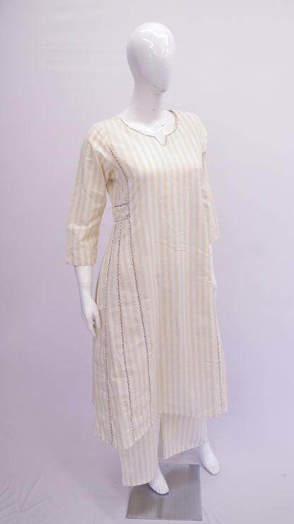 Mannequin wearing a long, light-colored dress with a subtle pattern on a plain background