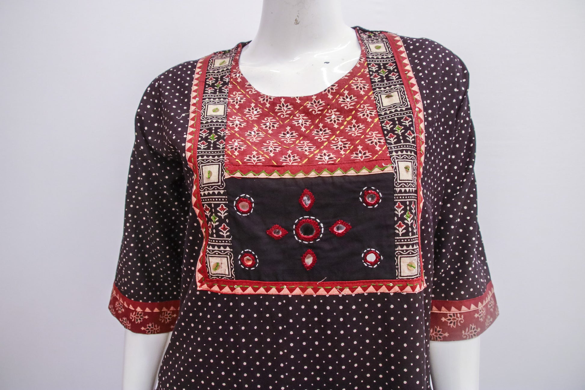 Traditional outfit with red and black patterns on a white background