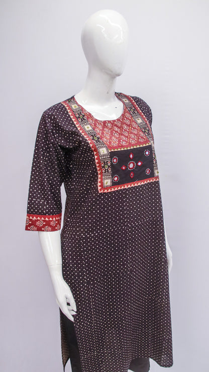 Black polka dot dress with red and white patterned neckline on a mannequin against a gray background