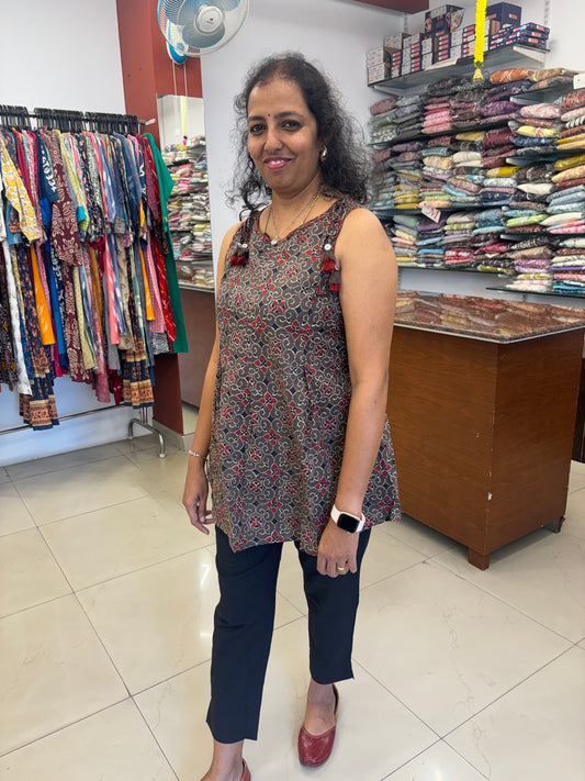 Woman standing in a room with shelves filled with books and fabrics.