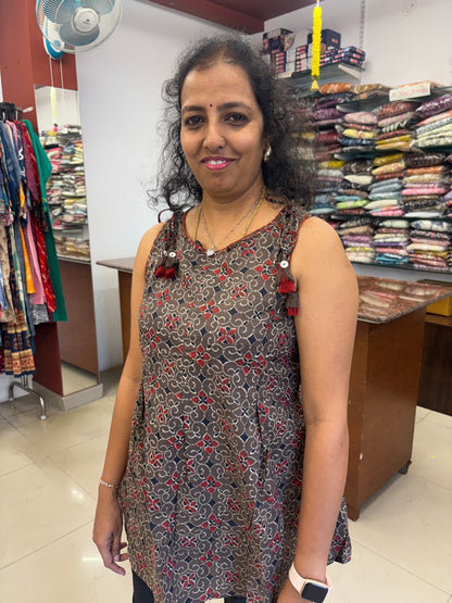 Woman standing in a store with shelves of fabric behind her