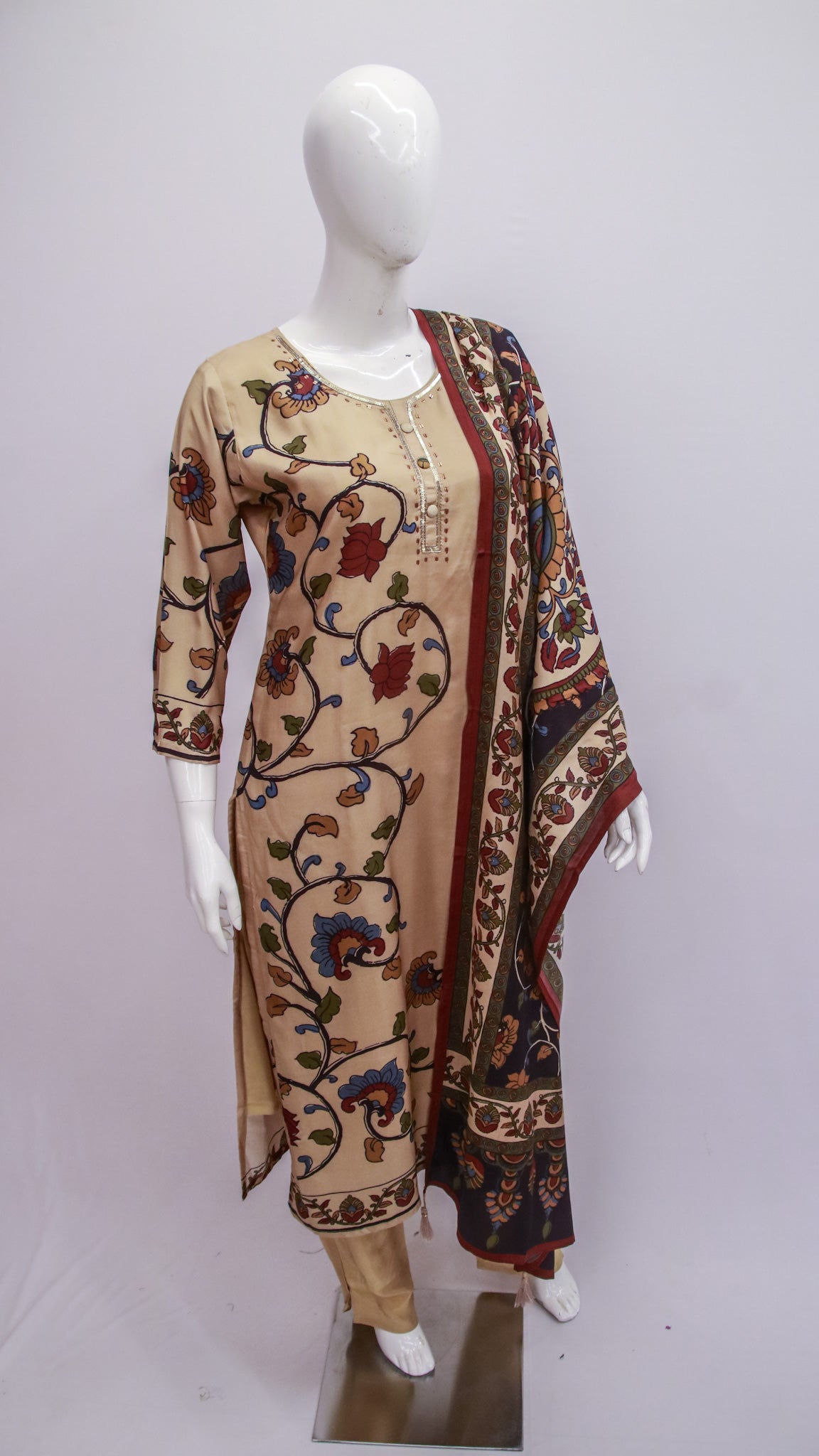 Mannequin wearing a beige dress with floral patterns and a matching long jacket on a white background