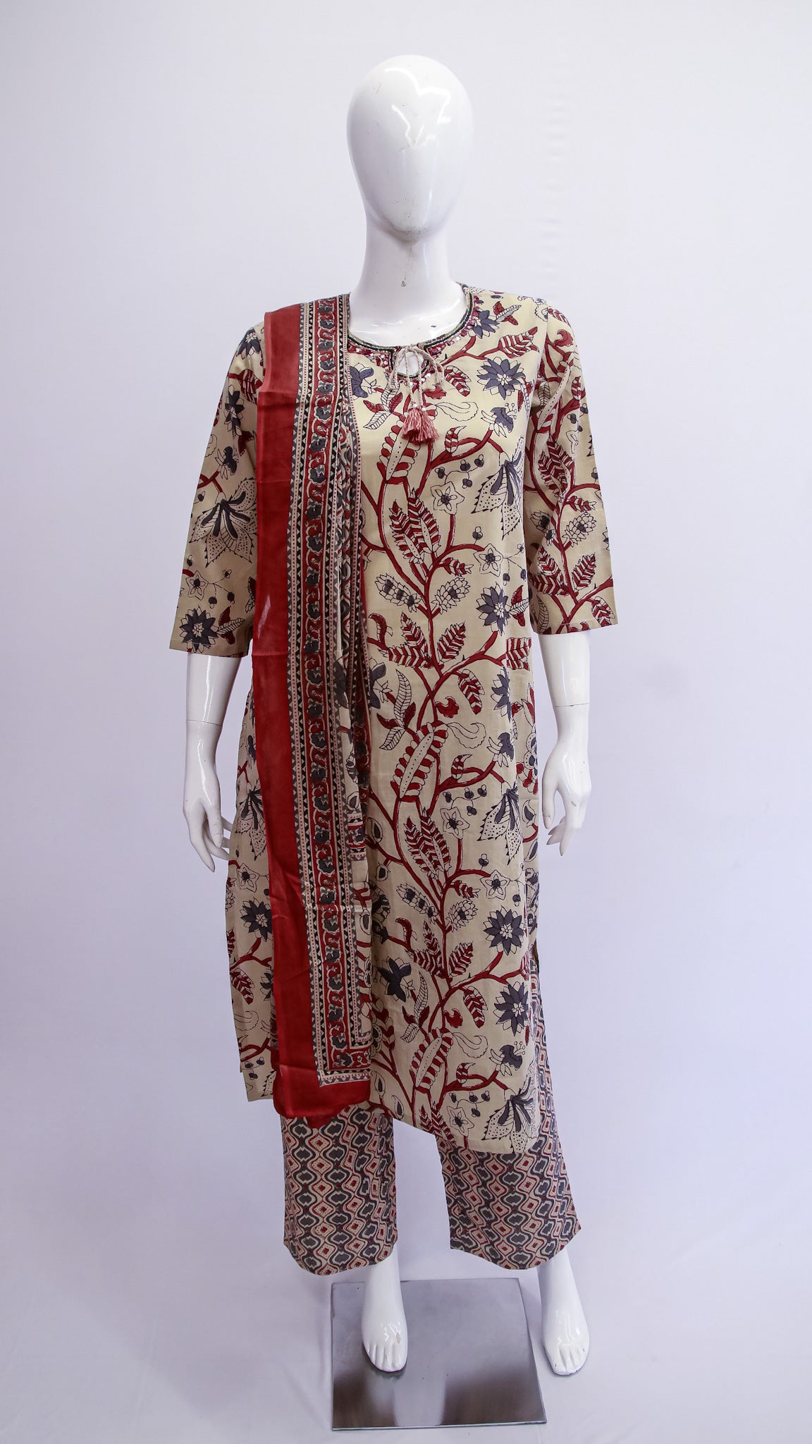 Mannequin wearing a patterned outfit with a red border on a white background