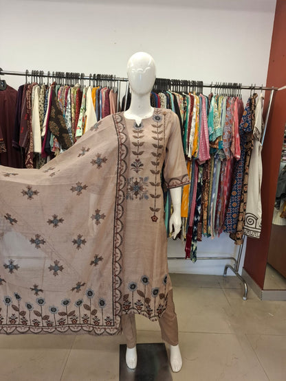 Mannequin wearing a brown embroidered outfit with a matching dupatta in a clothing store.