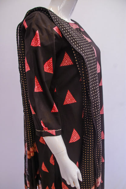 Mannequin wearing a black dress with red triangle patterns on a white background