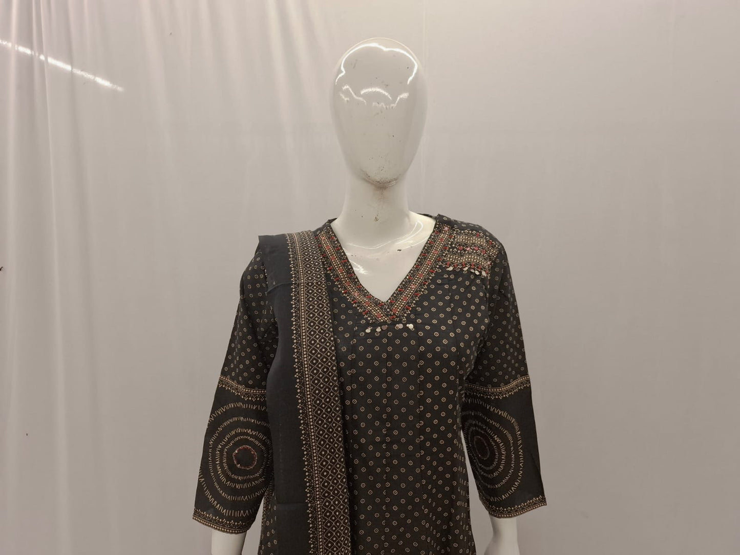 Black patterned dress on a mannequin against a plain background