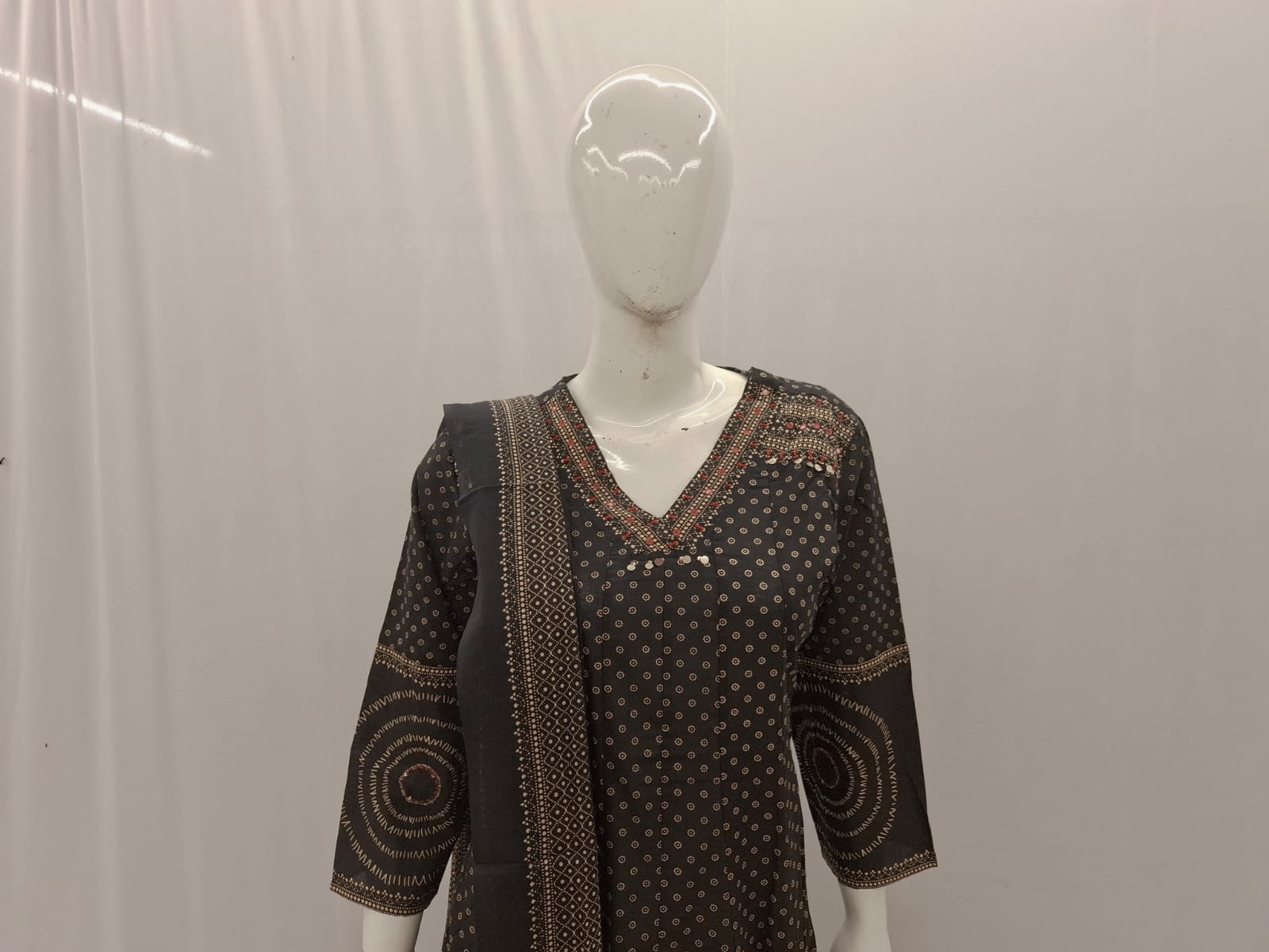 Black patterned dress on a mannequin against a plain background