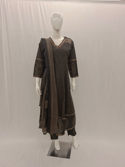 Mannequin wearing a brown patterned outfit with a long scarf on a white background