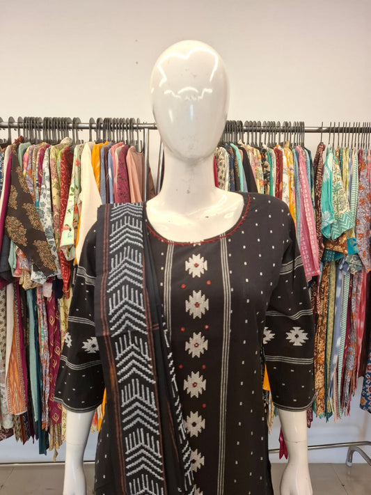 Mannequin wearing a patterned dress with a colorful clothing rack in the background
