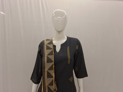 Black dress with gold patterns on a mannequin against a plain background