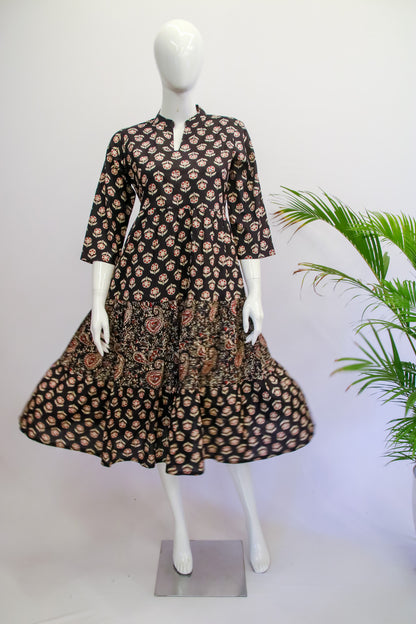 Mannequin wearing a black floral dress with a white background and green plant.