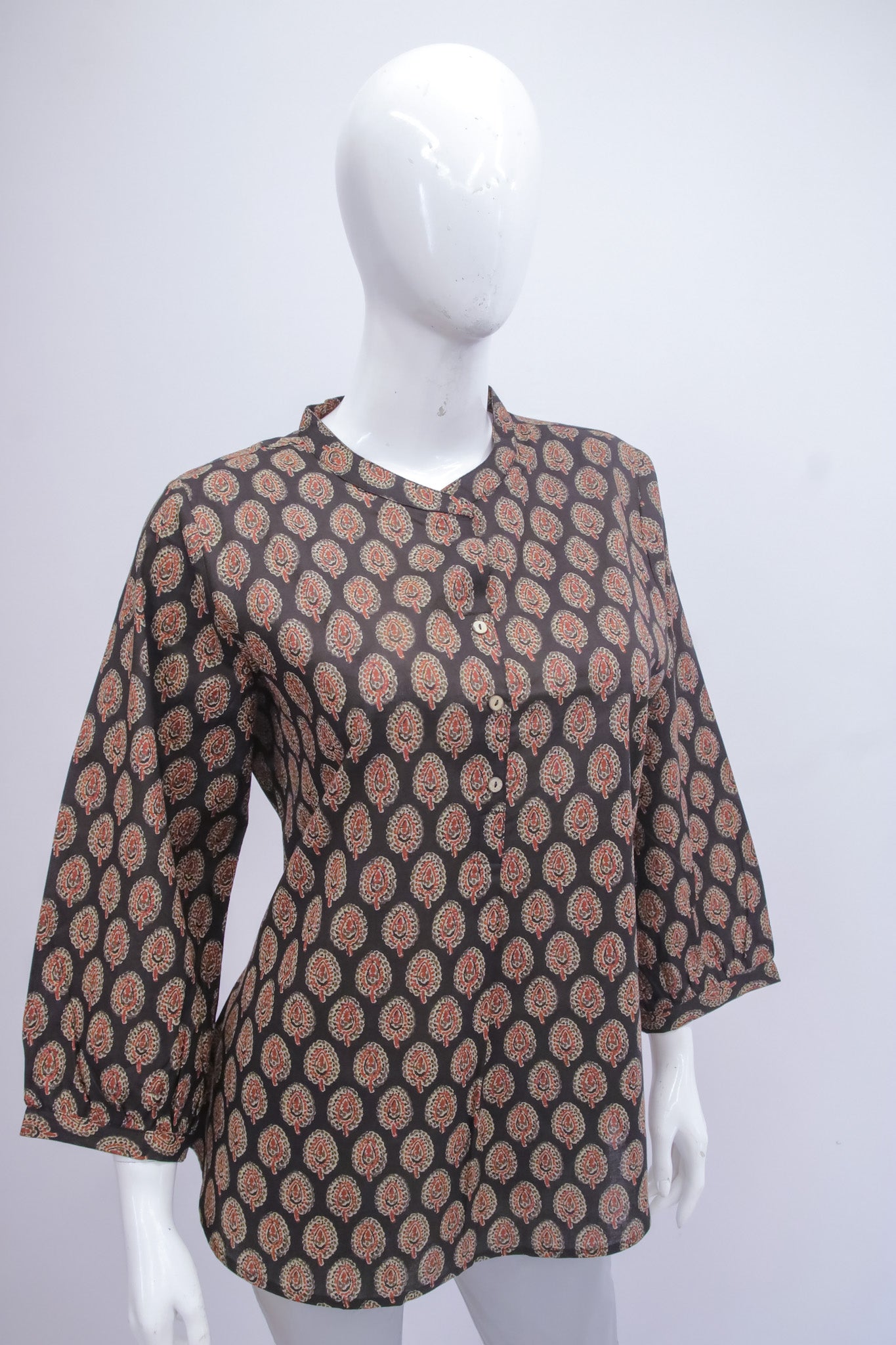 Patterned blouse on a mannequin against a white background
