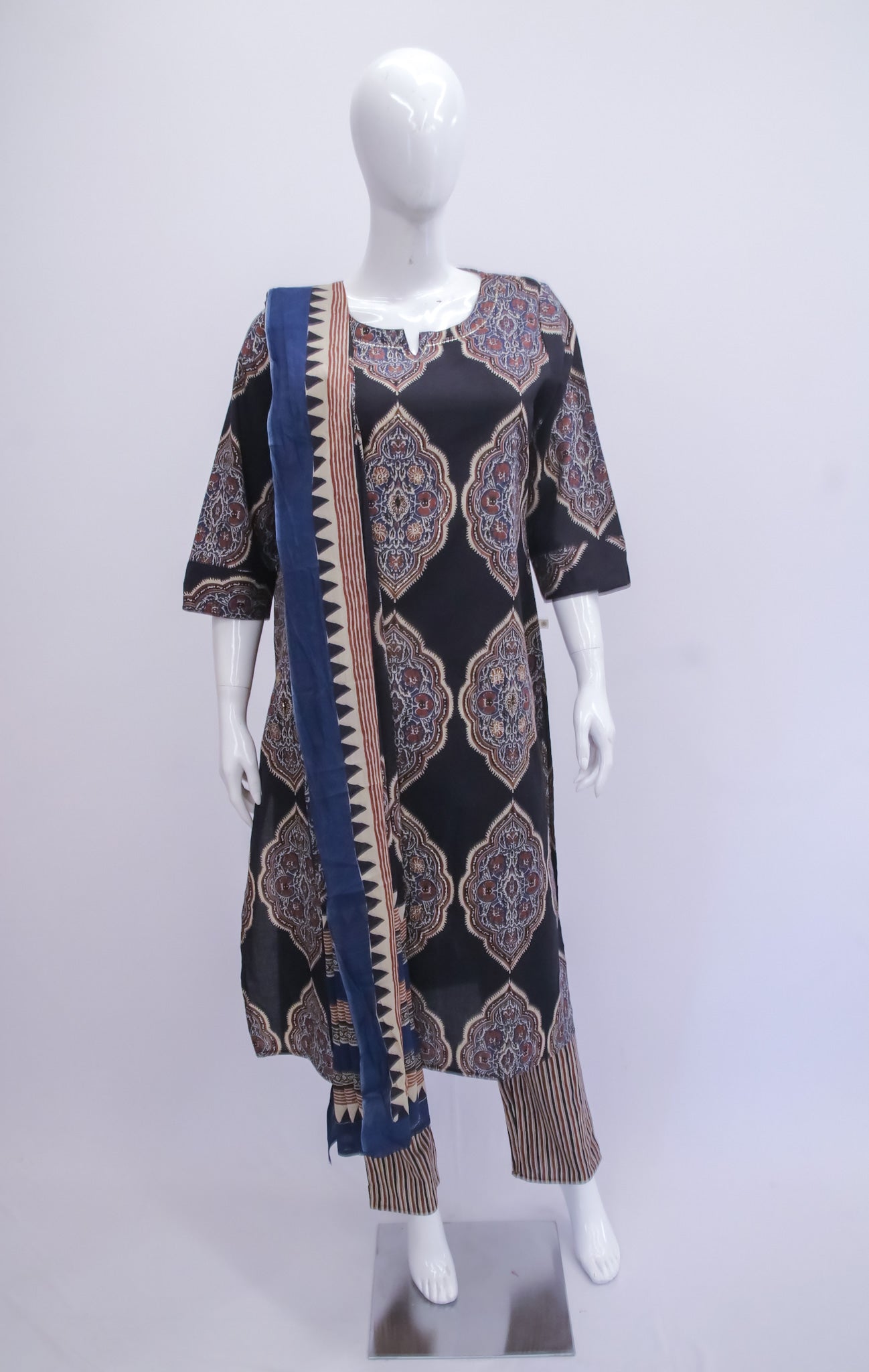 Mannequin wearing a black patterned dress with a blue and brown scarf on a white background