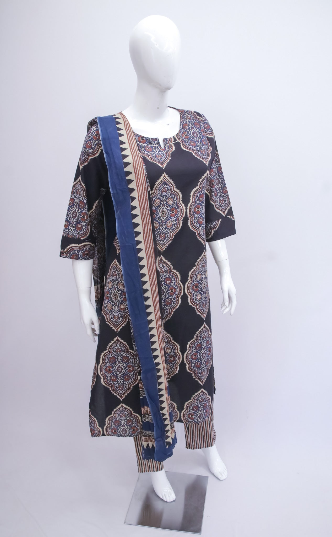 Mannequin wearing a patterned dress with a long scarf on a white background