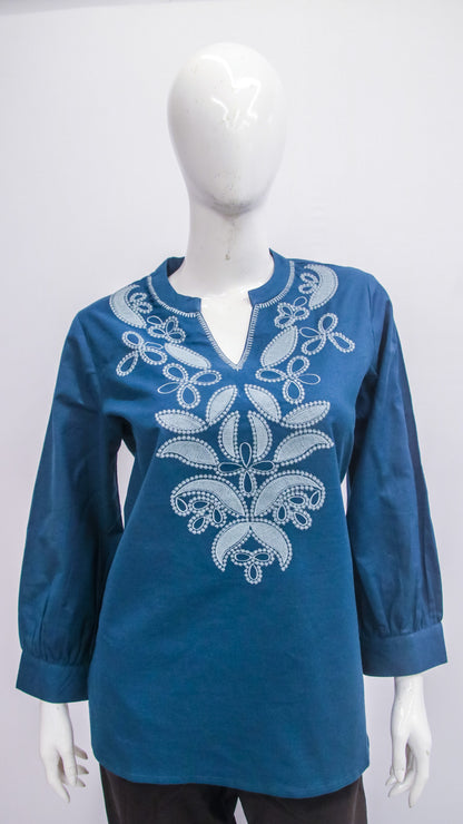 Blue embroidered blouse on a mannequin against a white background