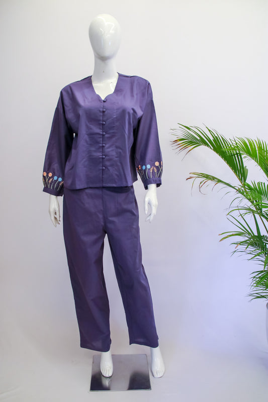 Mannequin wearing a purple outfit with floral cuffs against a white background