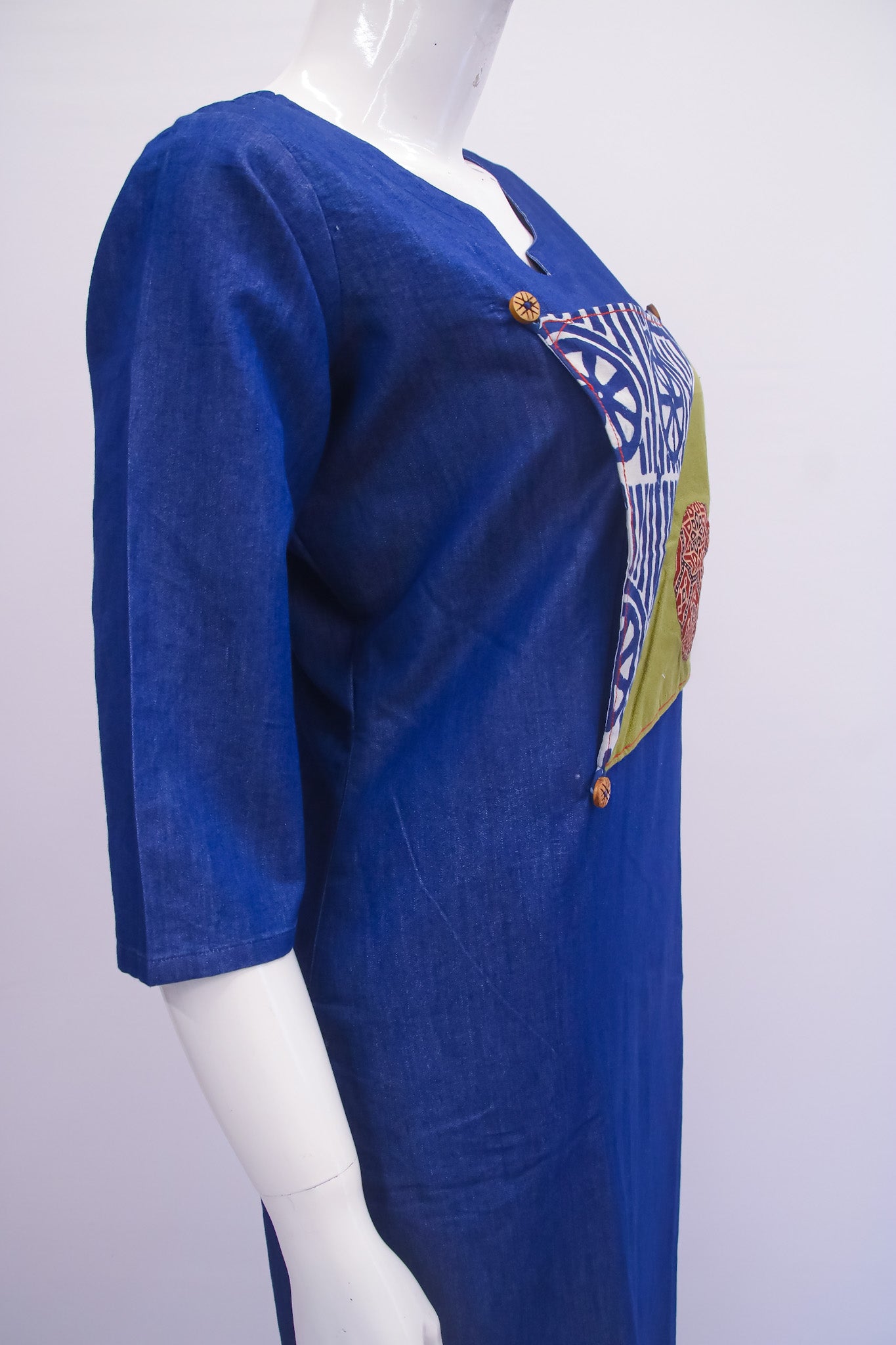 Blue dress with colorful patch on a white background