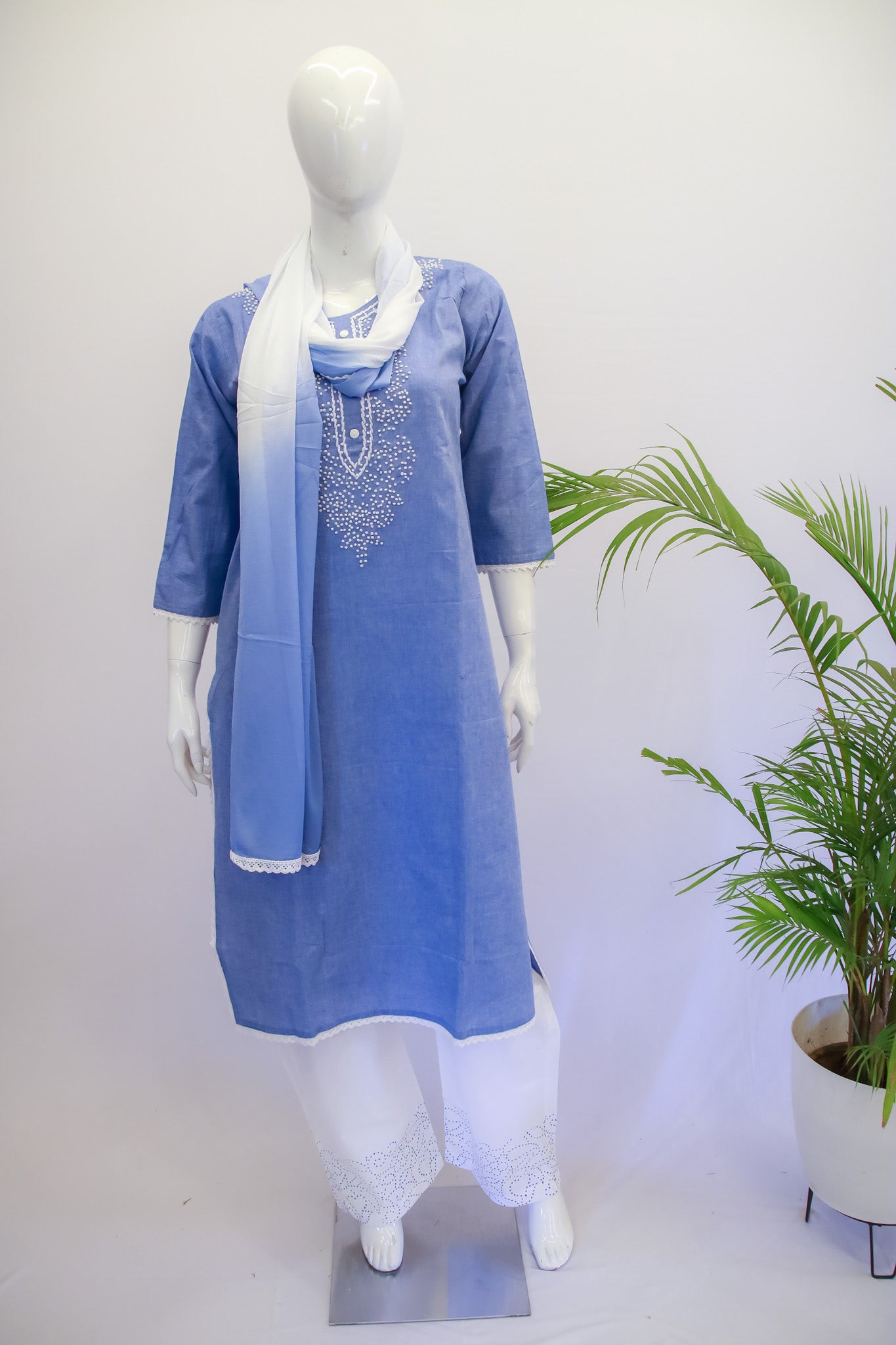 A mannequin displaying a blue cotton dupatta set with lace work on the kurta and dupatta, consisting of a kurta, pants, and a dupatta.