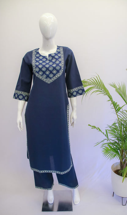 A mannequin displaying a blue color top and pant set with floral prints and applique work on the kurta.