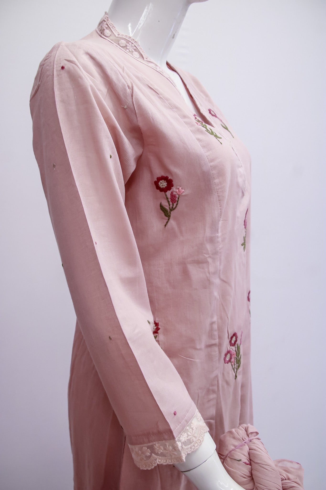 Pink embroidered dress on a mannequin against a white background