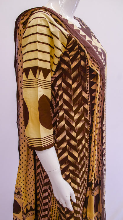 Mannequin wearing a patterned brown and yellow garment on a white background