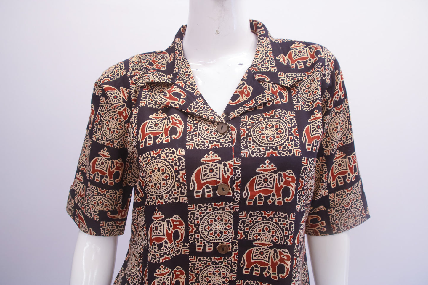 Mannequin wearing a patterned shirt with elephants on a white background