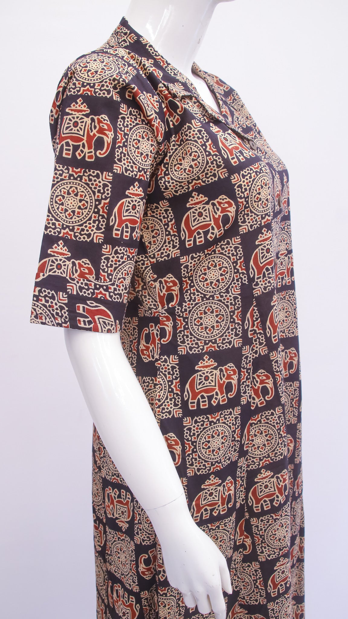 Mannequin wearing a patterned shirt with elephants and geometric designs on a white background