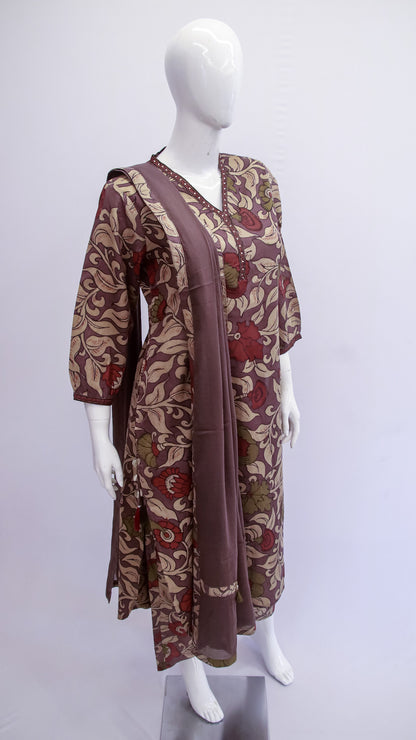 Mannequin wearing a patterned dress with a long scarf on a white background