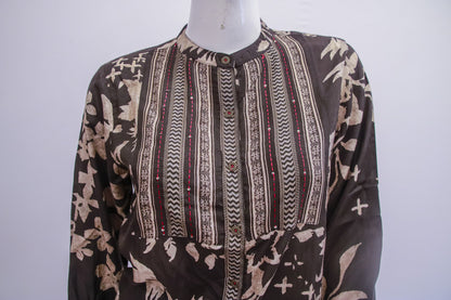 Mannequin wearing a patterned shirt with a brown and beige design on a white background