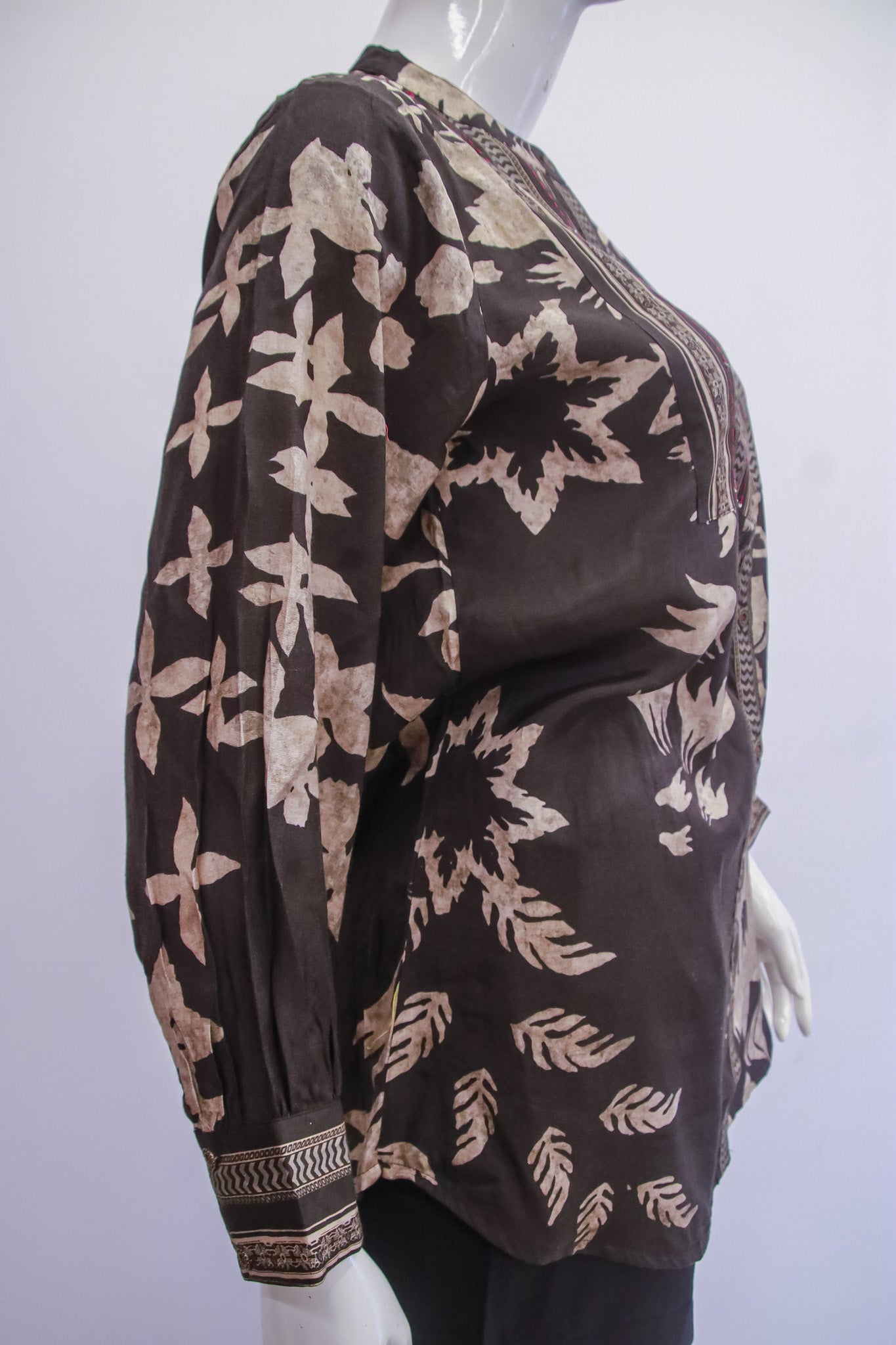 Mannequin wearing a brown floral-patterned top against a white background