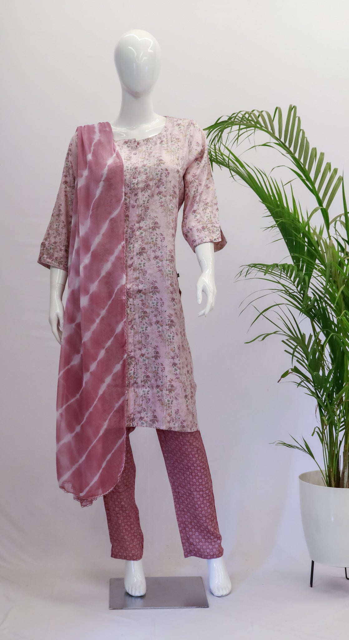 A mannequin displaying a pink and white capsule rayon dupatta set with floral prints, consisting of a kurta, pant, and dupatta.
