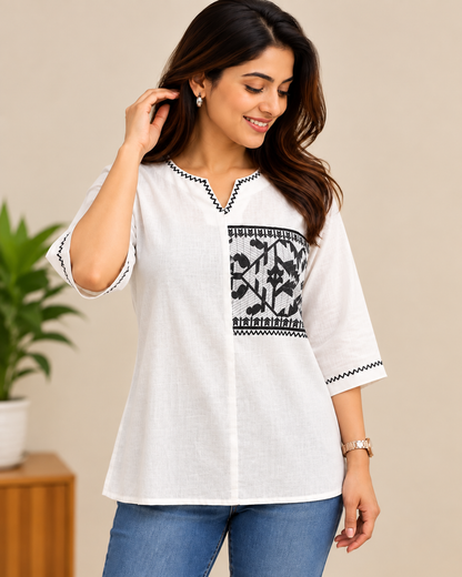 White cotton short top with black tribal print panel, V-slit neckline, and three-quarter sleeves with black zigzag detailing.