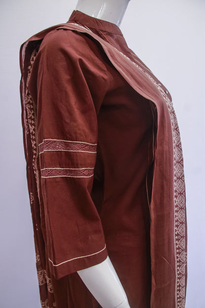 Brown traditional outfit with intricate patterns on a mannequin against a white background