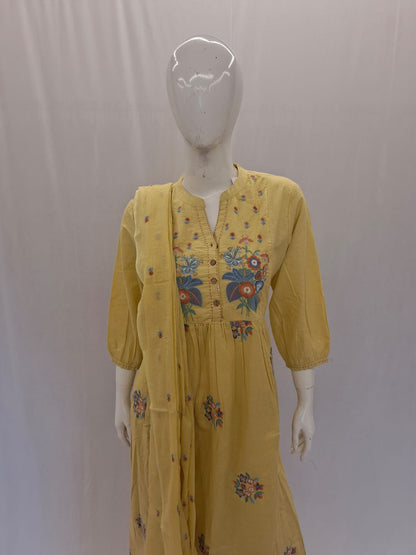Yellow dress with floral embroidery on a mannequin against a plain background