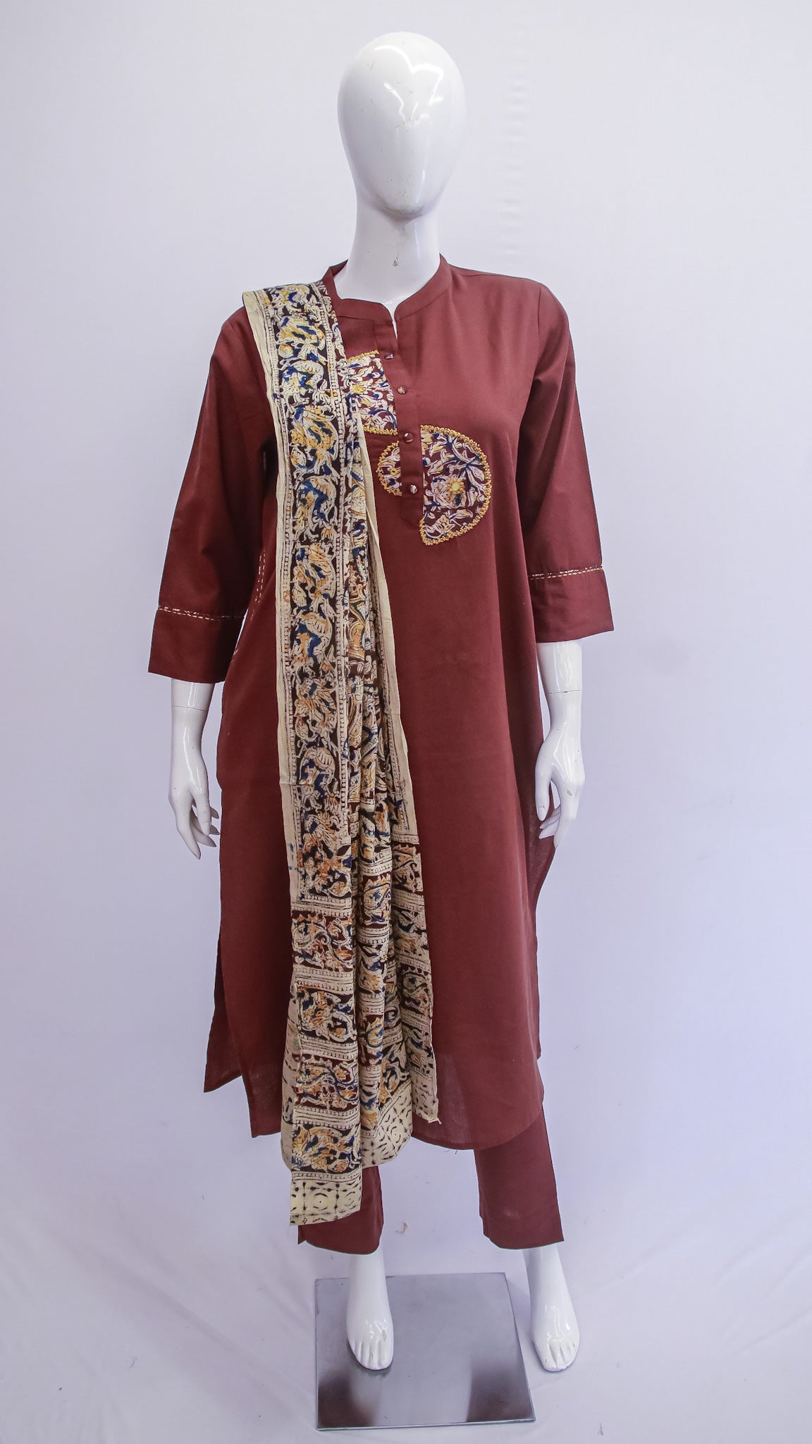 Maroon traditional outfit with a patterned scarf on a mannequin against a white background