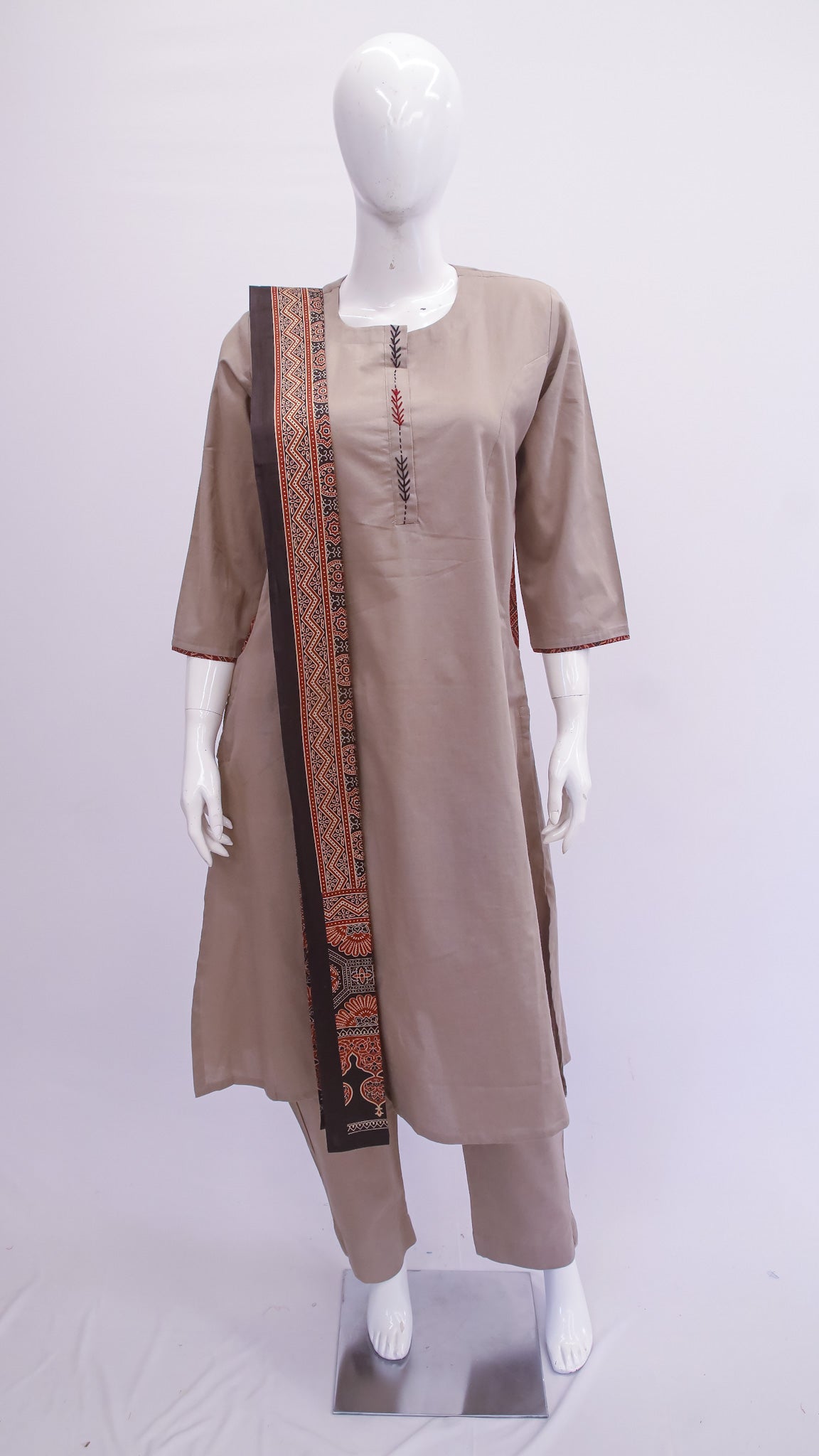 Mannequin wearing a beige kurta with a long skirt and border on a white background