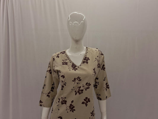 Mannequin wearing a beige floral-patterned shirt against a plain background