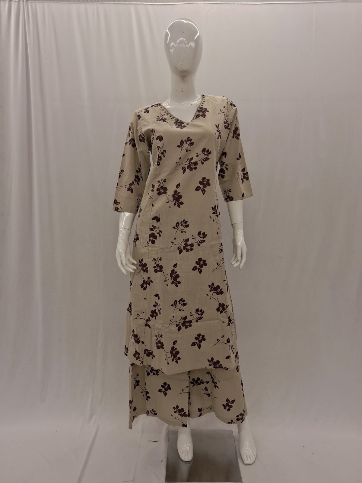 Beige floral dress on a mannequin against a white background