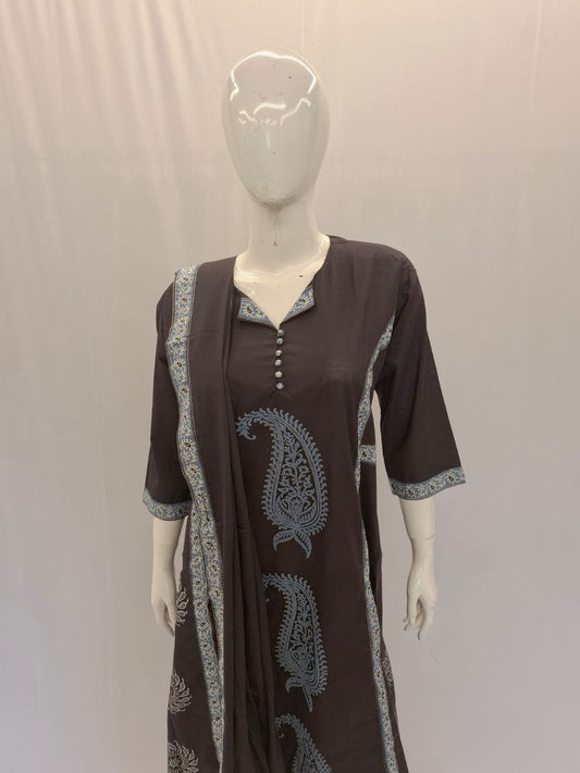 Brown dress with paisley patterns on a mannequin against a plain background