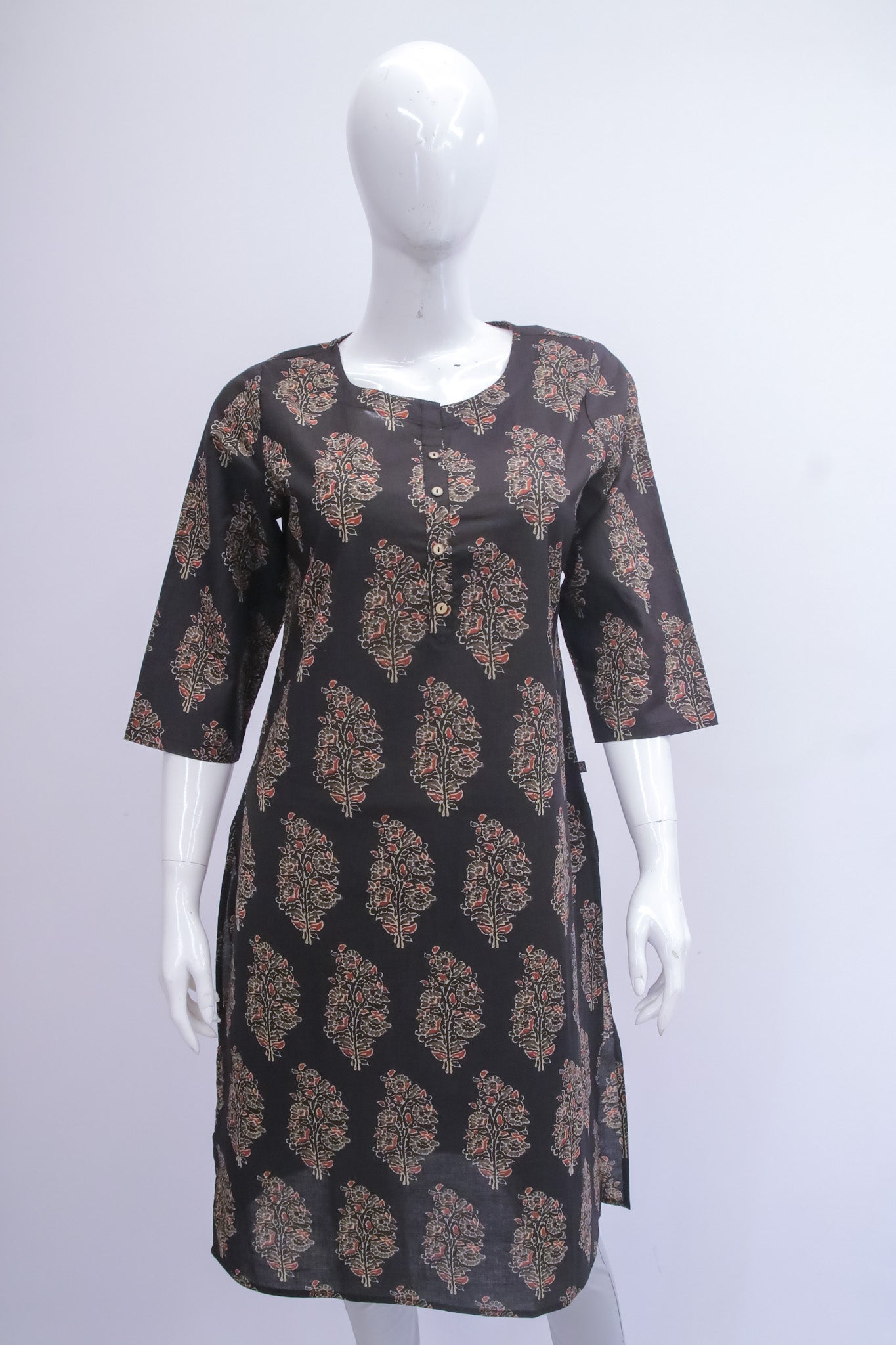 Black patterned dress on a white mannequin against a white background